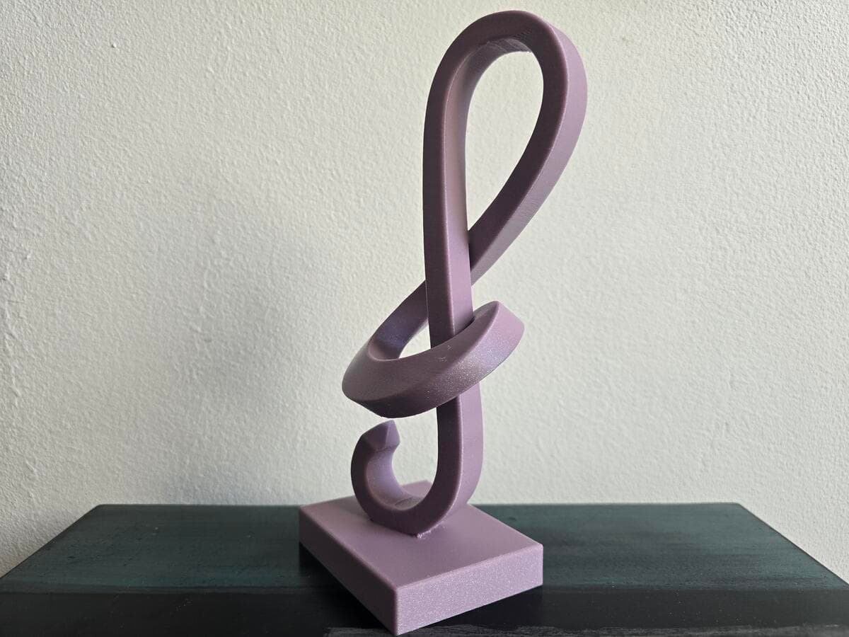 Escultura Clave de Sol vista lateral destacando a elegância da forma