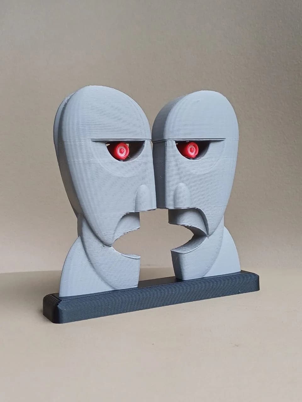 Escultura Dois Rostos vista em três quartos mostrando profundidade e textura artesanal