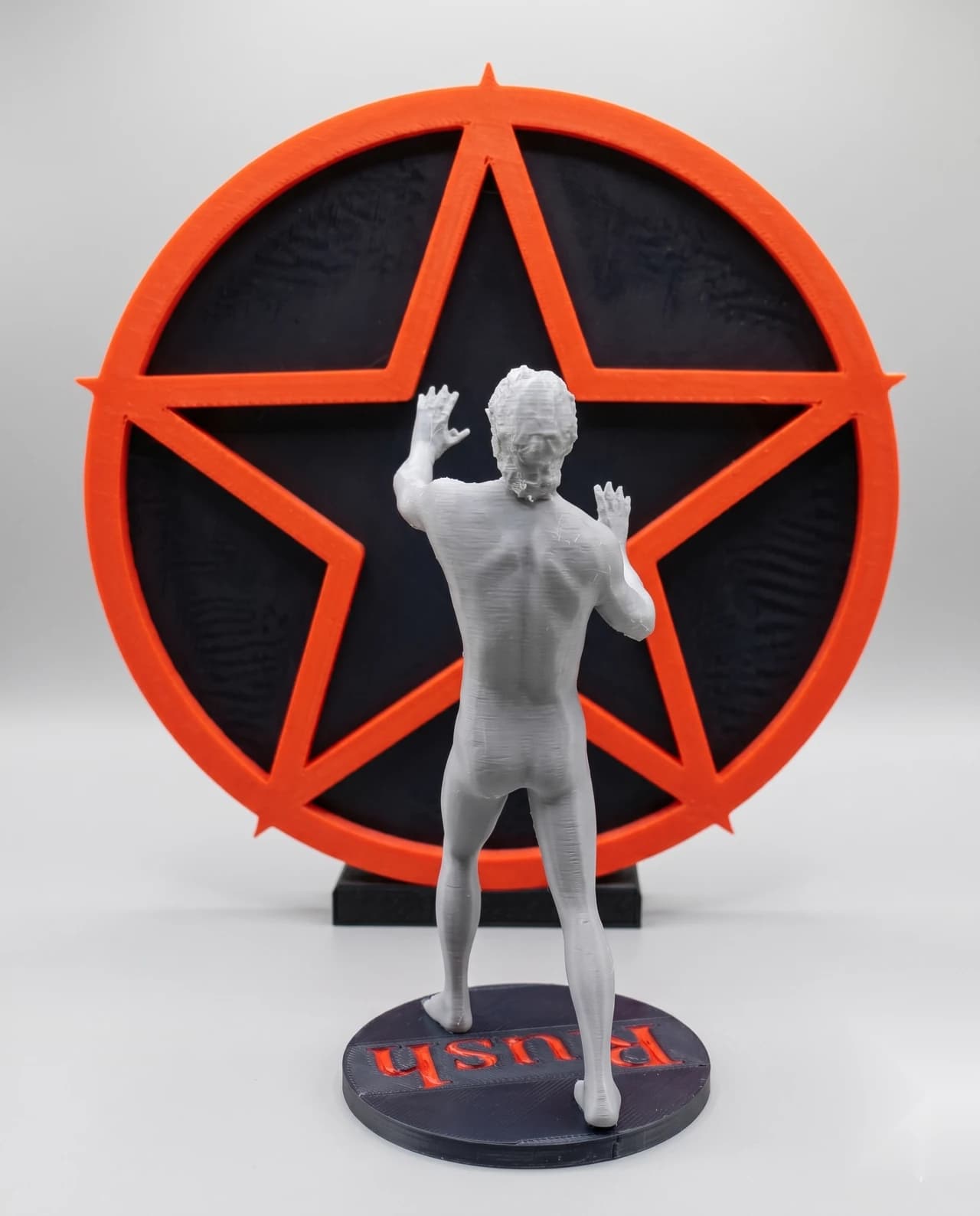 Escultura artesanal da figura na estrela, vista traseira ampla com a base