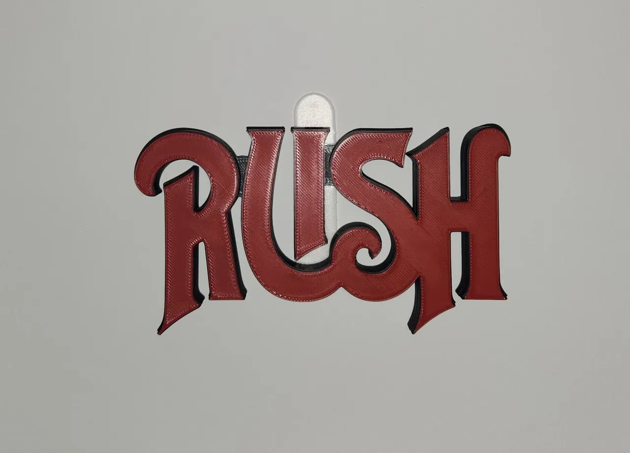 Escultura de logotipo em vermelho com contorno preto, vista frontal