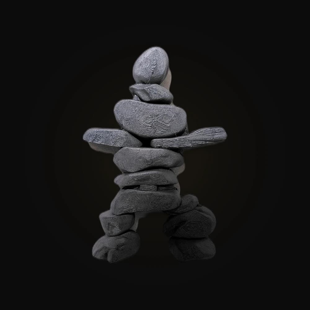 Escultura artesanal de figura humana feita de pedras empilhadas, em cinza grafite