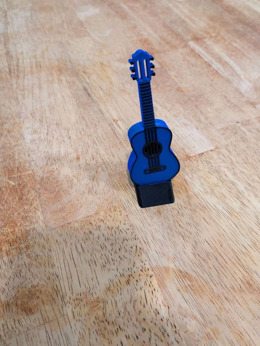 Detalhe do porta-palheta guitarra com palheta encaixada magneticamente