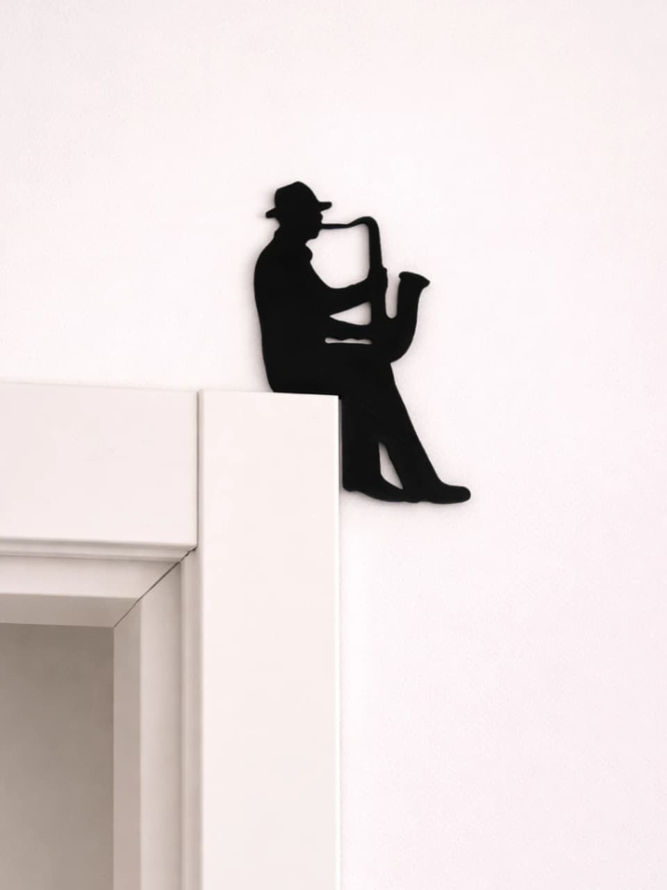 Saxofonista decorativo vista alternativa mostrando recorte fino preto na quina do batente